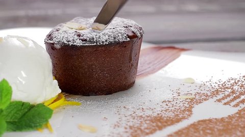 Warm cut chocolate fondant with ice cream and cinnamon. Beautiful serving dishes.