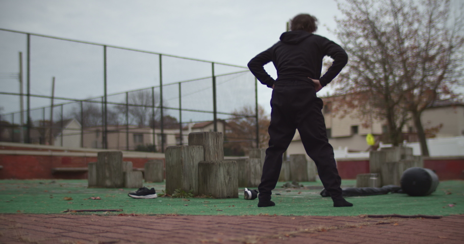 Teenager MMA training, working out in urban schoolyard. Warming up