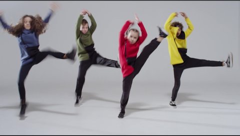 four kids at dance school. Ballet, hiphop, street, funky and modern dancers over white studio background. Children showing aerobic element. Sport, fitness and lifestyle concept.