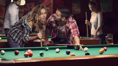 happy young people enjoying billiard game together
