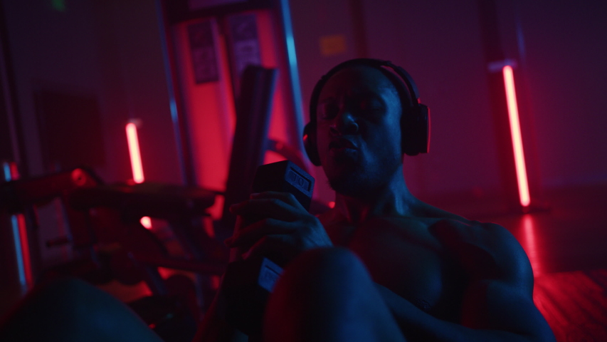 African-American athlete does crunches, working out, training in gym, dramatic lightning, shot on Red Weapon Helium
