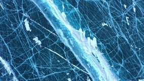Frozen Lake Baikal, Aerial view. Beautiful winter landscape with clear smooth ice. Famous natural landmark Russia. Blue transparent ice with deep cracks, top view of a frozen lake.  (No color grading) - Powered by Shutterstock - Get 15% off with code: PIKWIZARD15