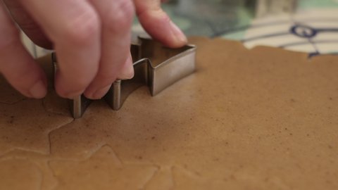 Cutting out Christmas gingerbread cookies in shape of Christmas tree. 4K resolution close up shot on a gimbal. Czech Republic