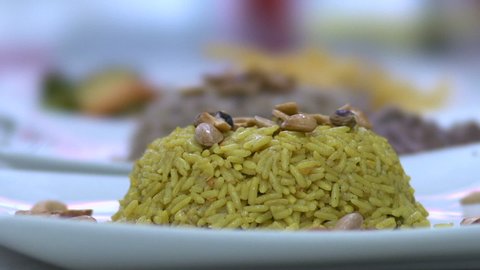 Sprinkling nuts on Kabsa, spiced rice, slow motion at 100 fps, Saudi cuisine