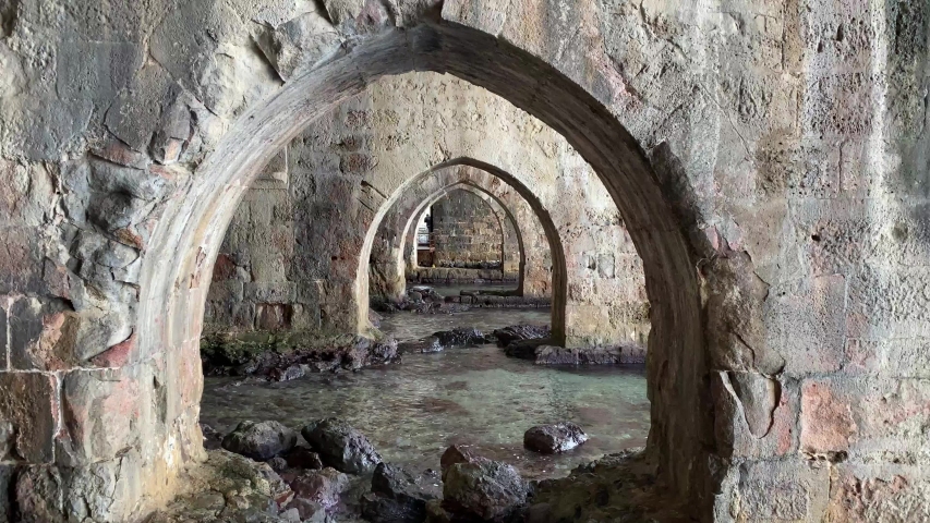 Perspective of the old shipyard through stone arches in Turkish Alanya to the West