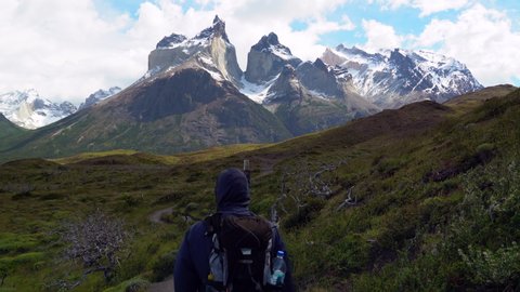 Hiker in Torres del Paine National Park in Chile with the iconic Cuernos del Paine mountains in the background, Patagonia, South America.