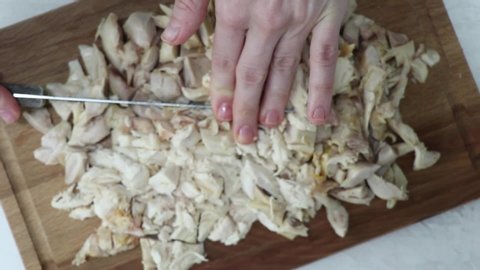 Woman cutting roasted chicken on a board