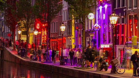 AMSTERDAM, NETHERLANDS - JULY 10 2019: city night illumination famous red lights district canal panorama 4k timelapse circa july 10 2019 amsterdam, netherlands.