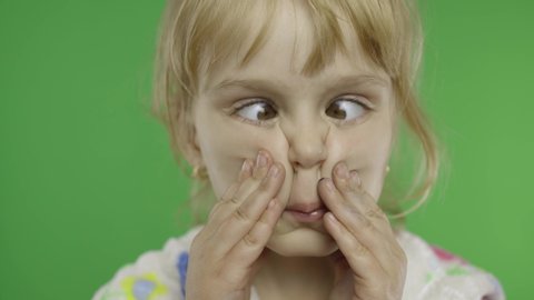 Pretty child making crazy face with her eyes. Portrait close up. Cute little blonde child, 4-5 years old. Green screen. Chroma Key