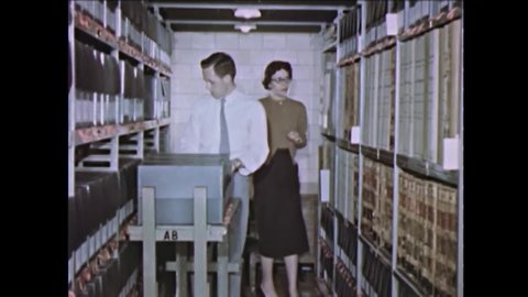 CIRCA 1949 - Men and women are seen working in the stacks of the US National Archives.