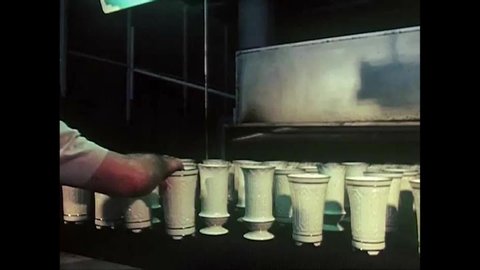 CIRCA 1970s - At a manufacturing plant, decorated china is put into a kiln a final time before the gold trim is varnished. A final inspection is made.