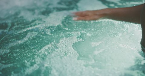 Close up of a woman's hands in a hot tub, spa wellness and relaxation concept
