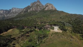 4K aerial summer sunny morning footage of beautiful green Devil's Peak slopes with white stone columns Cecil Rhodes Monument, Table Mountain National Park, Cape Town, Western Cape, South Africa