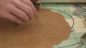 Women hands cutting out Christmas gingerbread cookies. 4K resolution Close up shot on a gimbal.