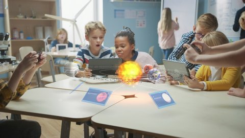 Стоковое видео: Group of School Children in Science Class Use Digital Tablet Computers with Augmented Reality Software, Looking at Educational 3D Animation Of Solar System. VFX, Special Effects Render