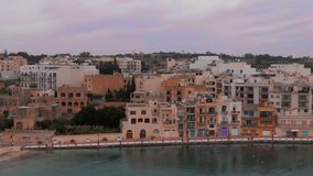 Flies over European houses on the island of Malta, roofs and windows in the frame. Aerial video