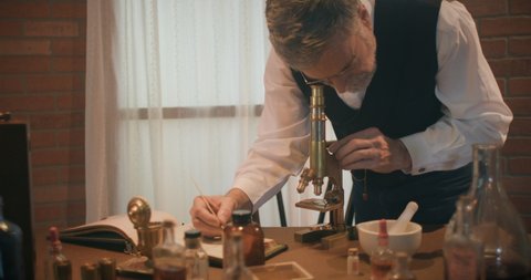 A Victorian era scientist working in his laboratory using a dip pen to document observations made through a brass microscope typical of the time period.