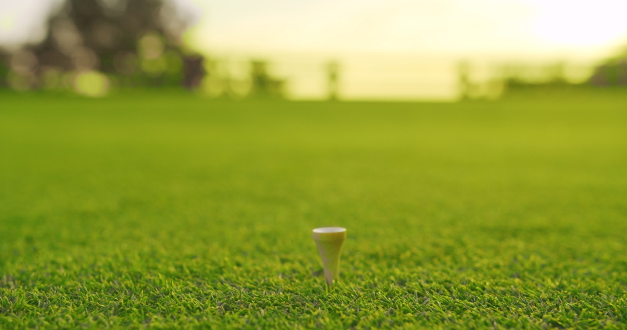Golfer placing golf ball on the tee at golf course. Closeup. | Shutterstock HD Video #1043793850