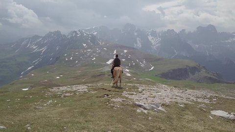 Drone circling around a cowboy admiring the stunning view while sitting on his horse.