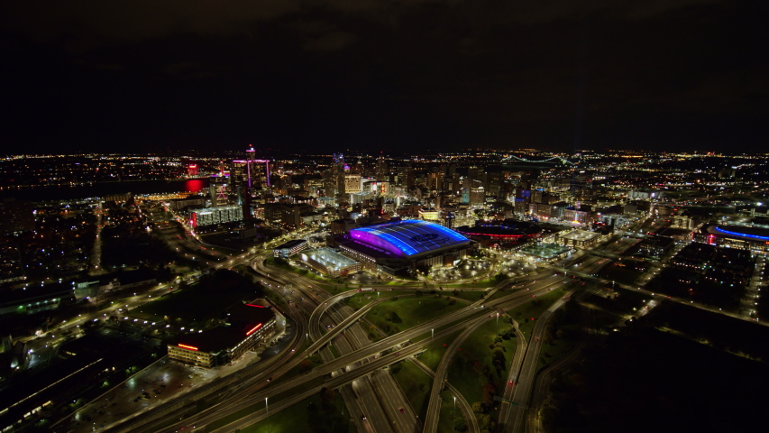 Detroit Michigan Aerial v153 Nighttime downtown cityscape from stadium view to river and bridge - October 2017