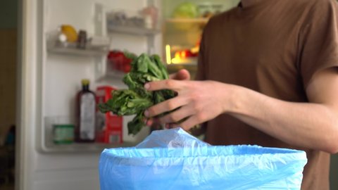 Household Food and Drink Waste. A man are chucking out fresh vegetables and salads that could have been consumed. This is going straight from fridge or cupboard into the bin