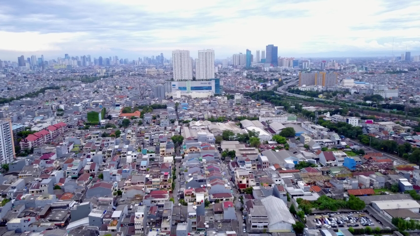 JAKARTA, INDONESIA - Juni 2018: Flying over low-rise residential houses towards office towers in central business district of Jakarta city, Indonesia.