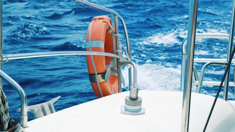 Safety bouy on back of catamaran sailing at sea