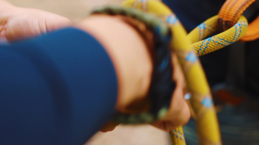 Female making knot in climbing rope