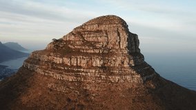 4K high quality aerial sunny morning footage of spectacular scenic Lion's Head Mountain, rocky hills with hiking trails, Atlantic Ocean coast panorama in Western Cape, Cape Town, South Africa