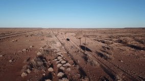 4K aerial drone video of sociable weavers nests on power pillars, gravel plains, wide dry bush savanna panorama near Upington, South Africa, N10 desert highway near Namibian border, southern Africa