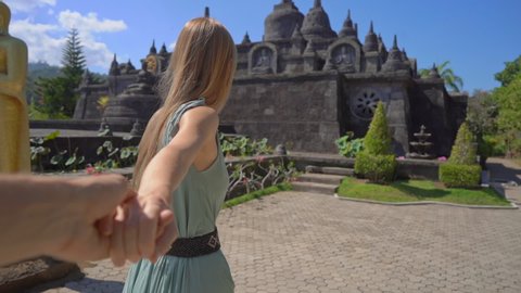 Slowmotion shot. Tourists woman and man visit the Brahma Vihara Arama temple on the Bali island, Indonesia. Bali Travel Concept