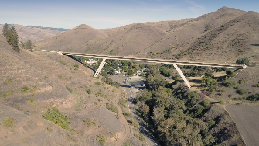 Aerial flying over the town of White Bird and highway bridge running over it. White Bird, Idaho, USA 