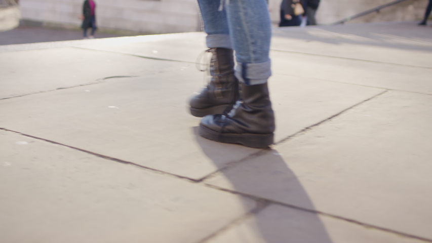 Legs of a trendy casual woman walking down some stairs, in slow motion