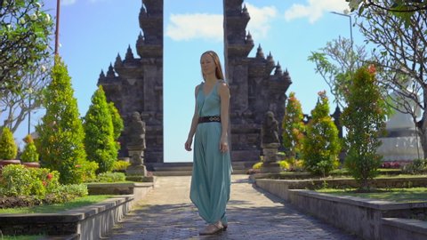Slowmotion shot. Young woman tourist visits the Brahma Vihara Arama temple on the Bali island, Indonesia. Bali Travel Concept
