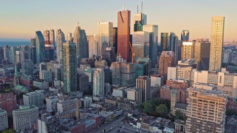 Aerial: Establishing shot of apartments & downtown Toronto city skyline at sunrise. Toronto, Ontario, Canada. 15 September 2019