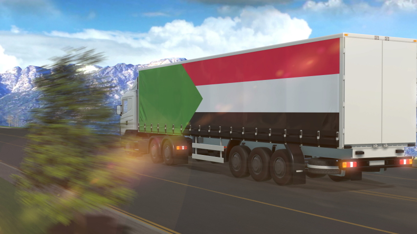 Sudan flag shown on the side of a large truck driving on a highway