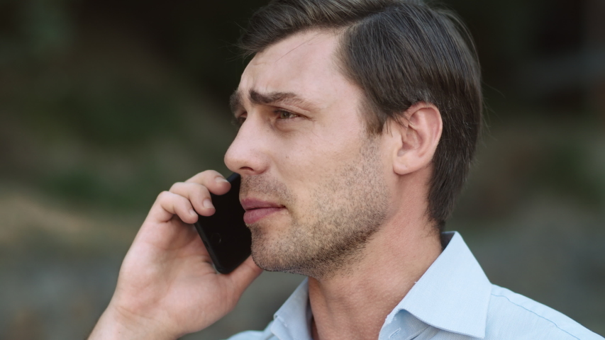 Portrait exhausted business man finishing phone talk at street. Tired businessman using mobile phone outdoor. Unhappy man looking away at modern street. | Shutterstock HD Video #1043915650