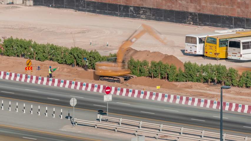 Constucting with special machines and engeneers near road with fast traffic in Business Bay, Dubai, United Arab Emirates aerial timelapse