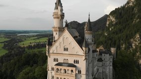 video shooting from the drone of a medieval castle on a sunny day against the backdrop of green forests and fields in the north of Germany, Neuschwanstein in Bavaria, and in Liechtenstein