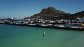 4K summer morning aerial drone video: spectacular Hout Bay harbour, boats, lagoon and beach. Hout Bay is Cape Town fishing harbour and residential suburb in Cape Peninsula, Western Cape, South Africa