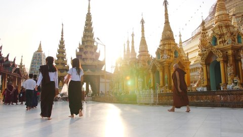 People Walking in Buddhist Temple Shwedagon. 4K Religion Concept Footage. 19 APR 2019 - Yangon, Myanmar.