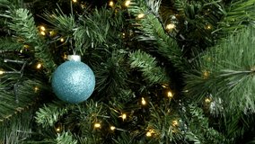 Lights and blue Christmas ball on tree branches 4K video