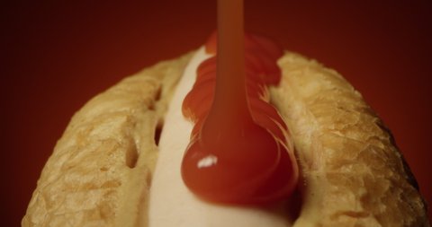 Ketchup Pouring on a Hot Dog with Sausage and Mustard on a Terra Cotta Background a Tracking Macro Shot of Hotdog with Laowa Lens