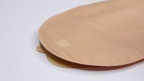 Colostomy bag, supply needed after colostomy surgery - colon cancer treatment. 2 piece ostomy bag with filter in skin color. Medical theme. Stoma bag ready to use