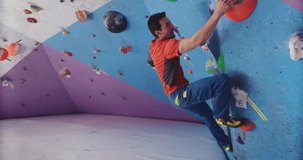 Young adult male training in indoor climbing gym