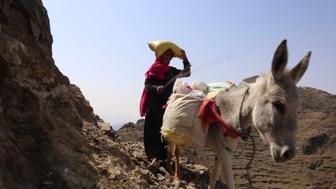 Taiz  Yemen - 02 Apr 2017: Yemeni women bring their food and drink needs across rugged mountain roads due to the Houthi militia blockade of the city of Taiz