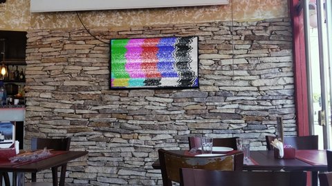 BUENOS AIRES, ARGENTINA - March 2020: TV on the Wall with Green Screen at an Empty Bar in Buenos Aires. Zoom In. 4K Resolution.