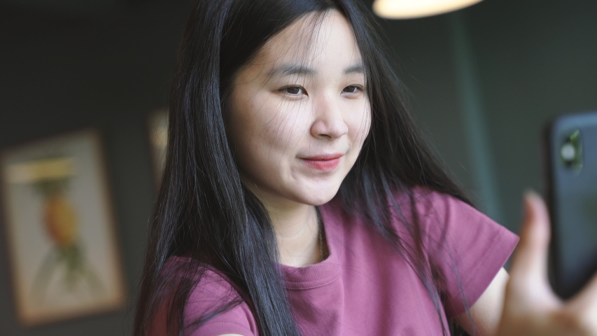 Young happy asian millennial woman taking a selfie and smiling with braces in the cafe, positive lifestyle female teenager 