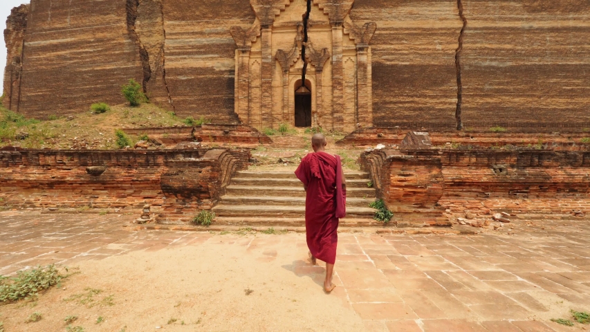Asian Monk Walking In Front Of Burmese Ancient Buddhist Temple. 4K Slow Motion Footage. Mandalay, Myanmar. Royalty-Free Stock Footage #1043985181