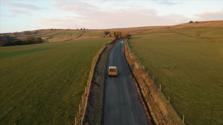 Aerial footage following a vehicle with a dog in the back. Narrow farmland road Royalty-Free Stock Footage #1043989111